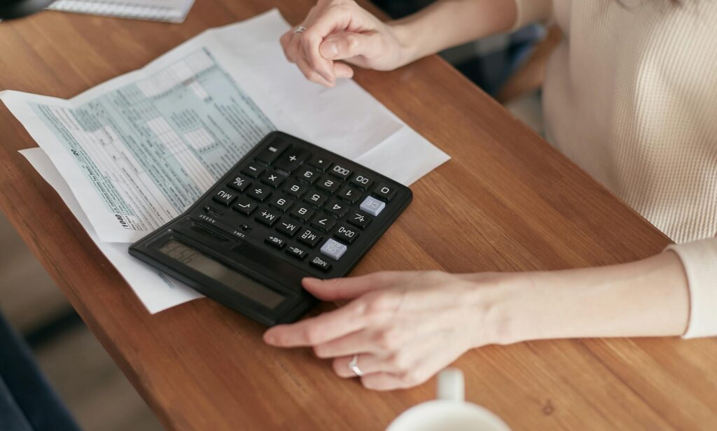 Focused individual using calculator to manage personal finances